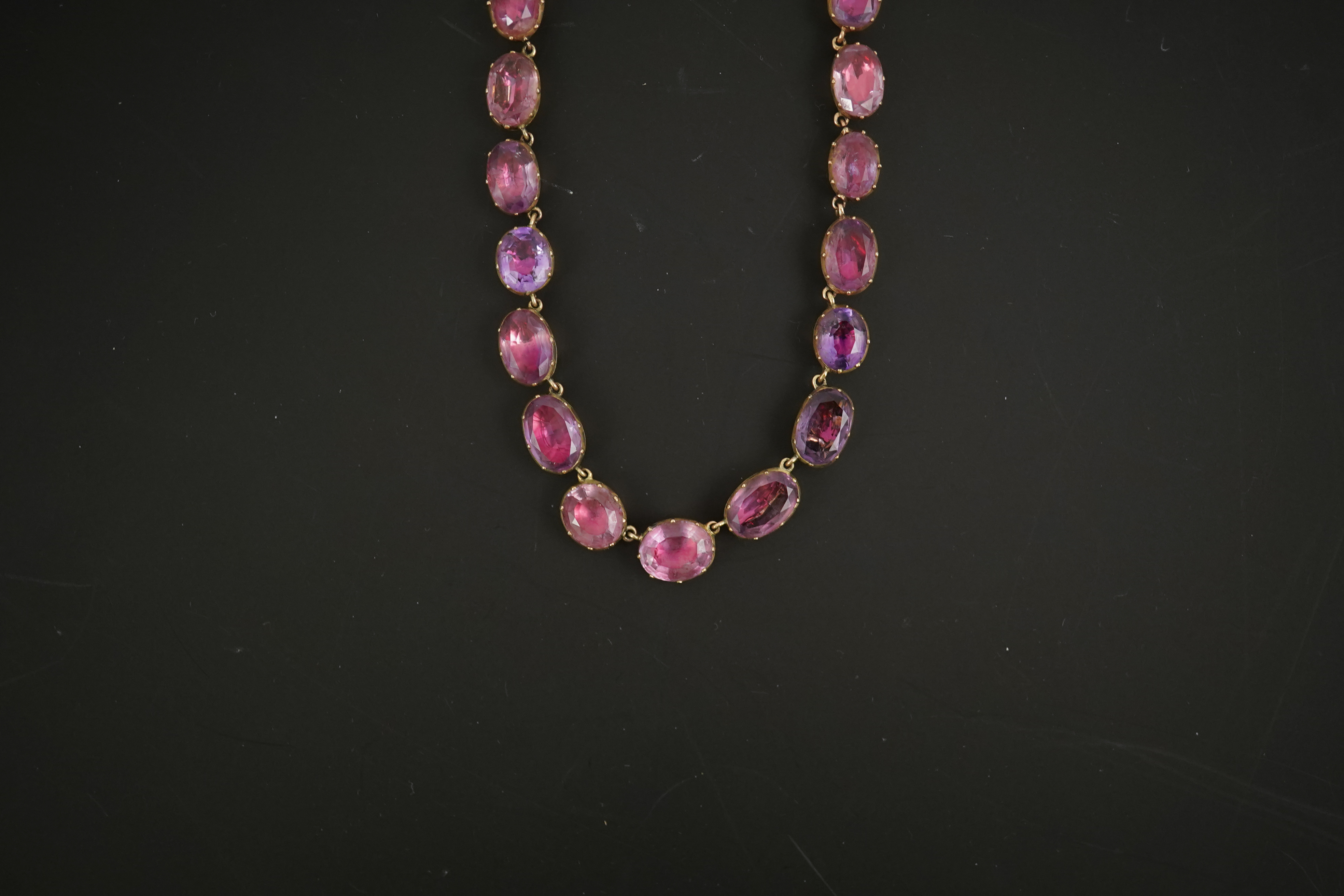 A 19th century gold and graduated oval cut foil backed amethyst or rock crystal set riviere necklace